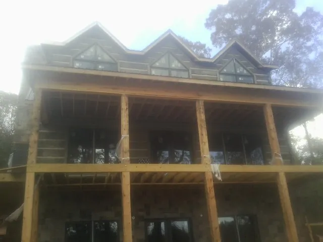 Dormers and porch framing on a large log home under construction — Roof Coating work by our crew in Perth Amboy