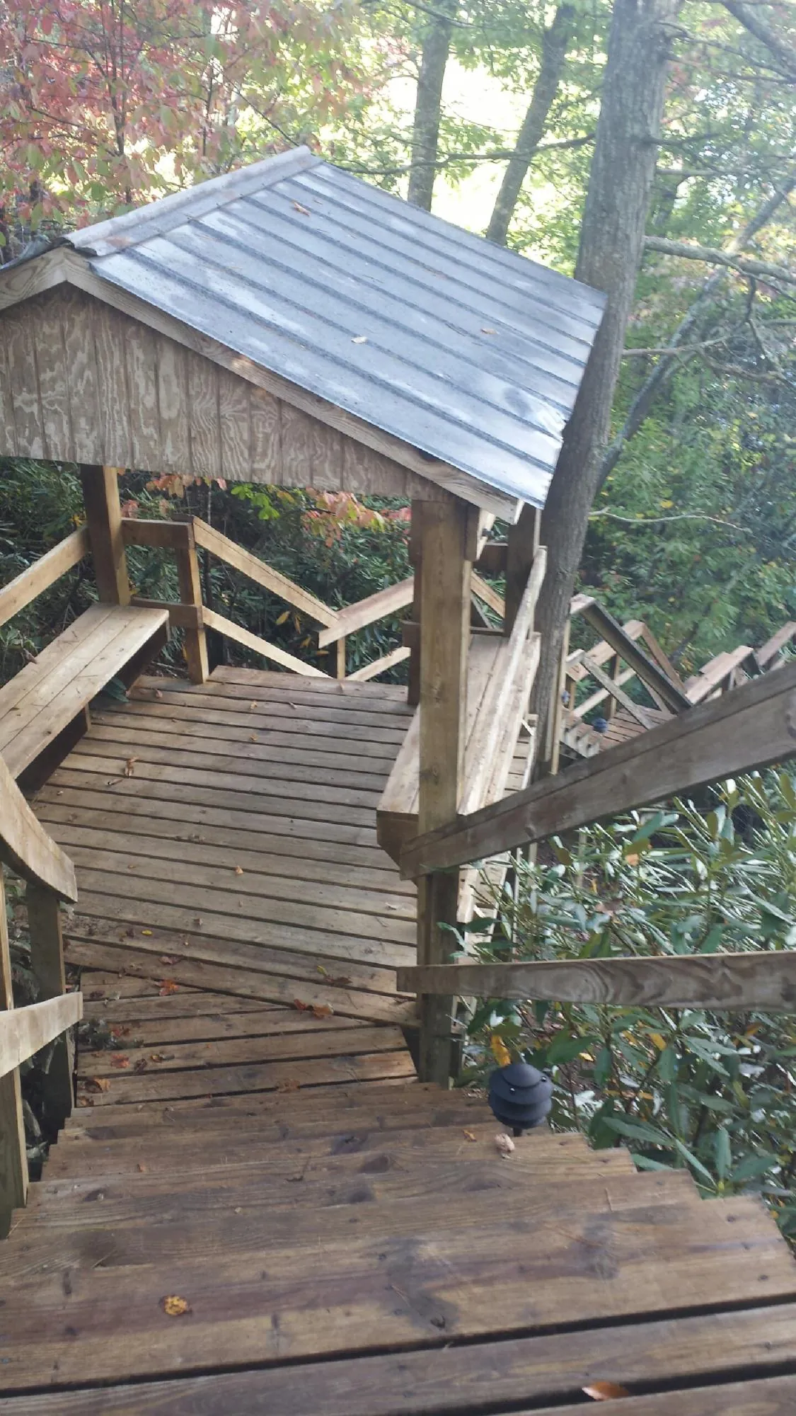 Metal roofed shelter over wooden steps on a wooded walkway — Skylight Repair & Installation work by our crew in Perth Amboy
