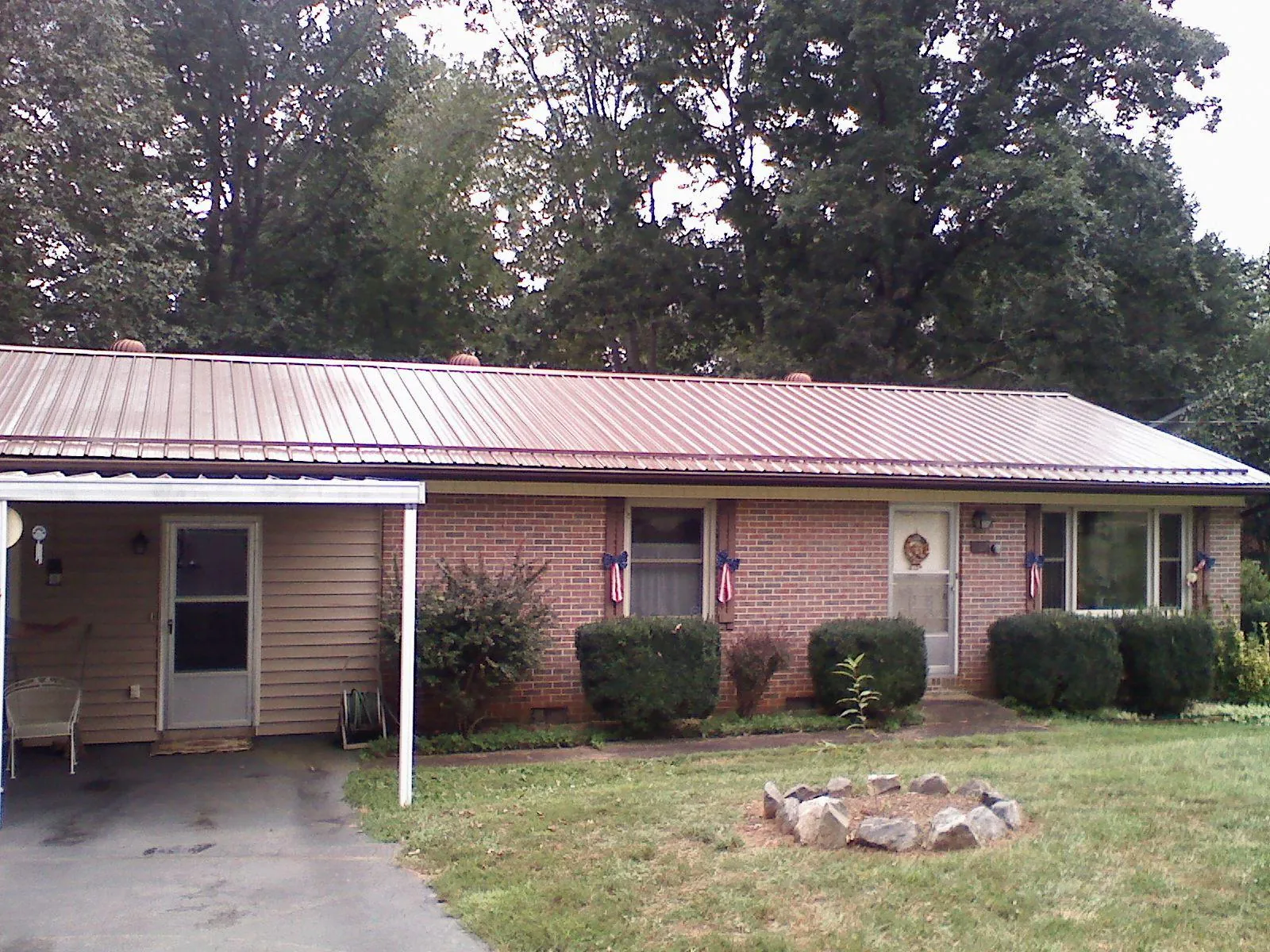 Bronze metal roof and carport on a brick ranch home — Roof Repair work by our crew in Perth Amboy